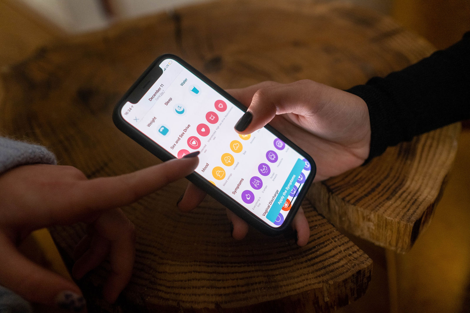 hands scrolling through period app on phone