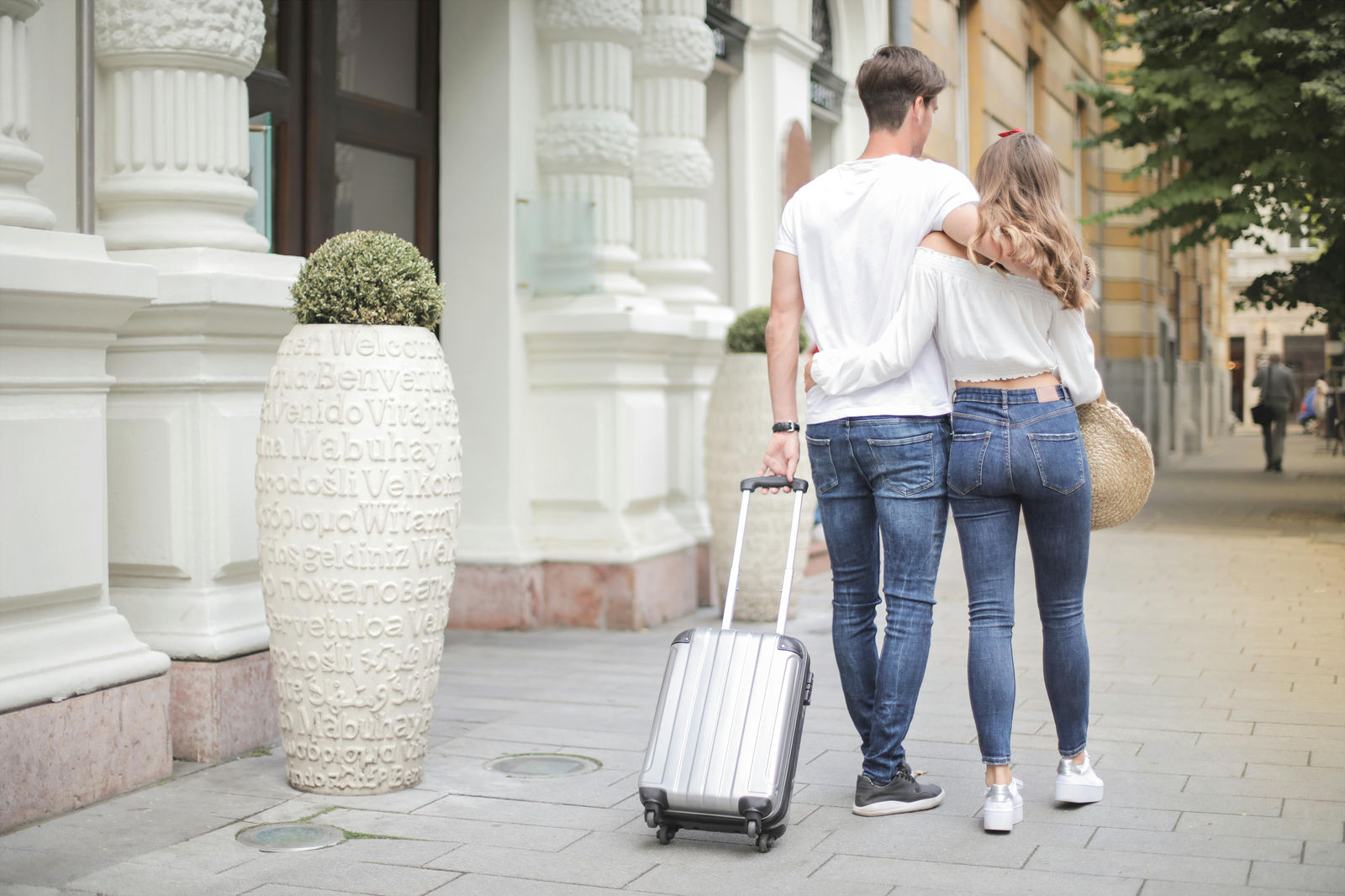 couple traveling and walking with a suitcase