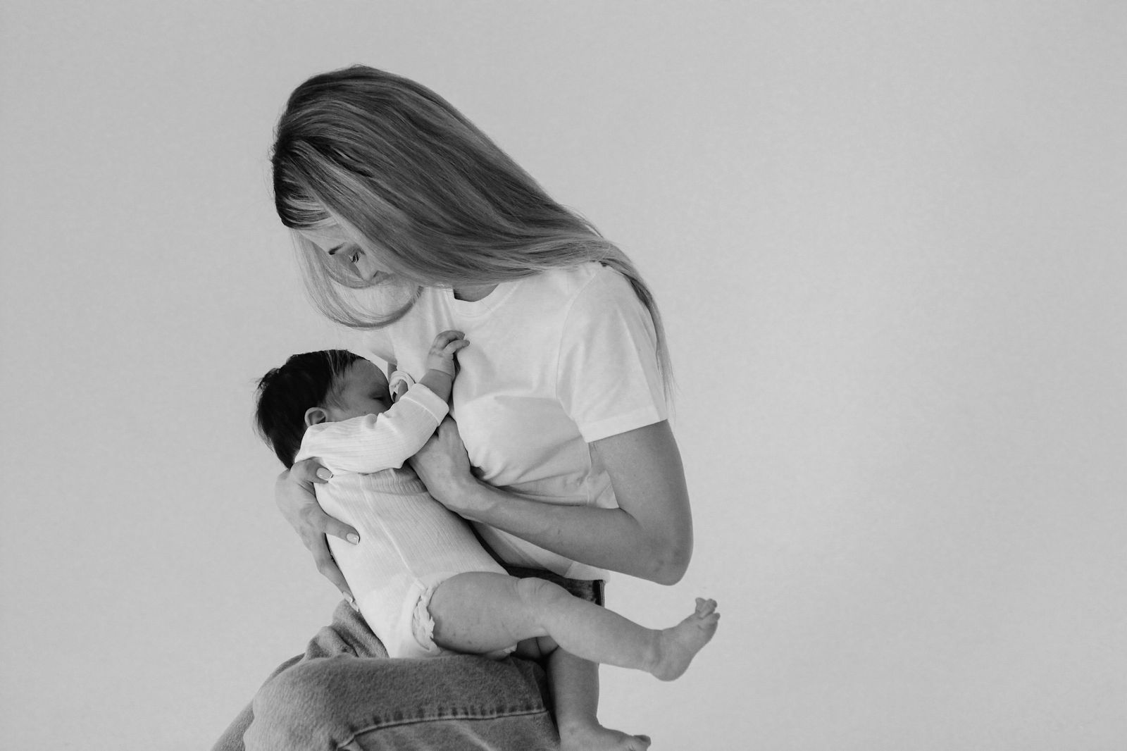 black and white photo of mother breastfeeding her baby